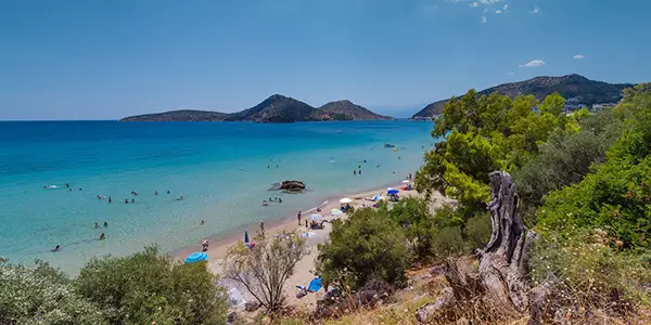 Photo of Tolo's sandy beach with the village in the distance